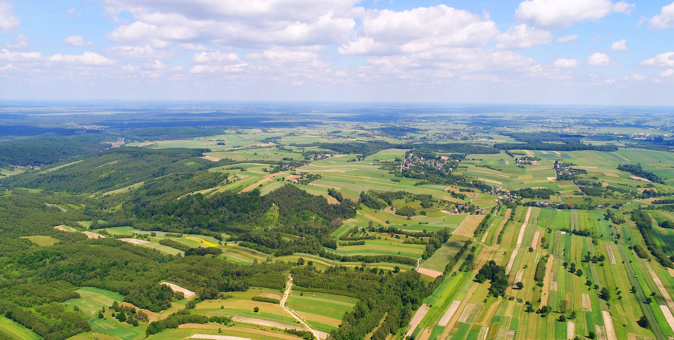 Strom- und Gaskosten nachhaltig senken – Energieberatung Luftaufnahme einer österreichischen Landschaft mit Feldern und Energieinfrastruktur