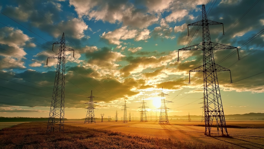 Power,Lines,Stretch,Across,A,Vast,Field,,Symbolizing,Energy’s,Omnipresence